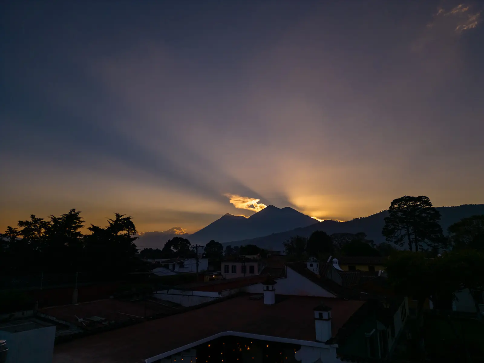 Sunset behind the volcanoes over the rooftops of Antigua Guatemala