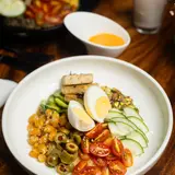 Mediterranean bowl with egg, chickpeas, cucumber, olives and tomato