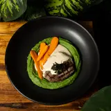 Tenderloin medallion over spinach purée with carrots and a creamy sauce