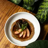 Braised oxtail with demi-glace and pickled radishes over cauliflower purée
