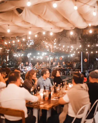 The Rosanta garden at night, with string lights and full tables