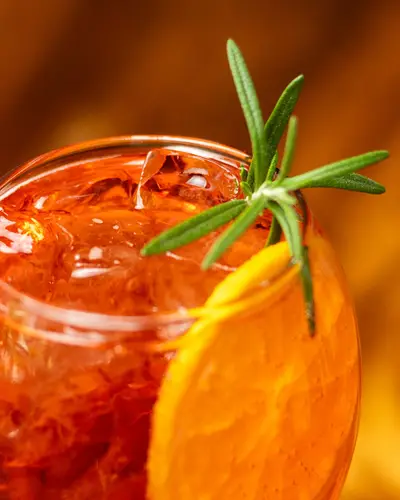 Cocktail with orange and rosemary on the wooden bar